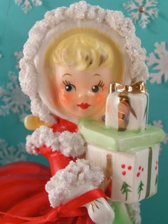 a small figurine is holding a present in front of some snowflakes