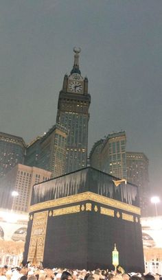 a large group of people standing in front of a building with a clock on it