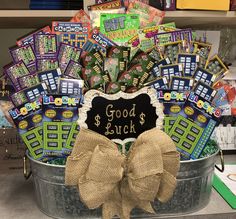 a metal bucket filled with lots of good luck cards and a bow on the front