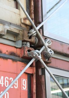 a close up of the side of a building with metal bars and screws attached to it