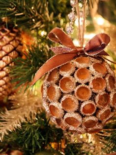 an ornament hanging from a christmas tree decorated with pine cones and cinnamons