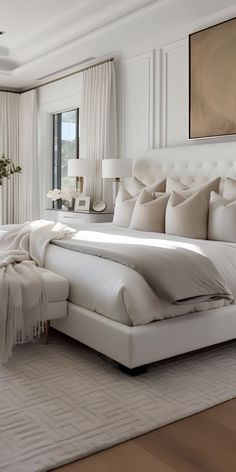 a large white bed sitting in a bedroom next to a window