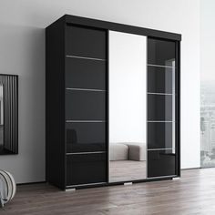 a black and white closet with mirrored doors in an empty room next to a window