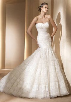 a woman in a white wedding dress posing for the camera