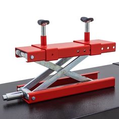 a pair of scissor stands sitting on top of a desk with two red handles