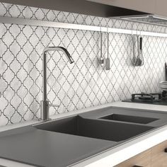 a modern kitchen with black and white tile backsplash, stainless steel faucet, sink, and countertop