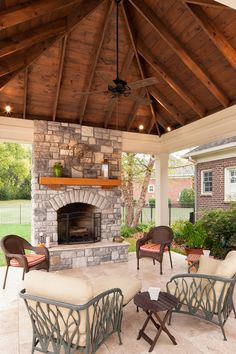 an outdoor living area with fireplace and chairs