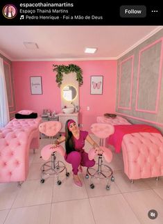 a woman sitting in a room with pink furniture