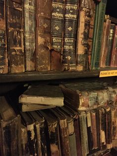 an old book shelf filled with books and other antique books on top of each other