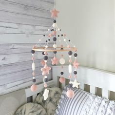 a baby crib mobile with pink and grey stars hanging from it's side