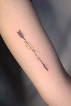 a small arrow tattoo on the arm