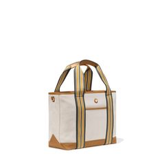 Hit the road, take to the skies or head to the beach with the handsome Cabana tote from Paravel. Crafted of creamy, textured canvas with a stain-repellant coating, the durable bag is accented with tan vegan leather details and straps striped jauntily in olive, mustard and white. Carry the tote to the office or pool, use as your personal item on flights or pack for overnight trips. The water-resistant blue satin lining finishes the medium bag with a secret touch of luxury.   • Durable, stain-repe Beige Canvas Bag For On-the-go, Beige Duck Canvas Shoulder Bag For Travel, Summer Canvas Bag For On-the-go, Cream Coated Canvas Everyday Bag, Beige Functional Canvas Bag, Cream Coated Canvas Bag For Daily Use, Cream Coated Canvas Bag, Daily Use Cream Coated Canvas Bag, Cream Coated Canvas Bag With Canvas Lining