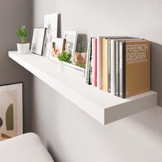 some books are sitting on a white shelf