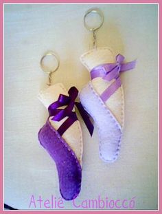 two keychains made to look like shoes with purple ribbon and bows on them