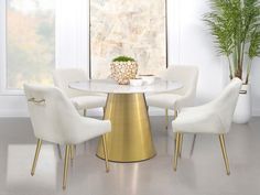 a white and gold dining table with four chairs