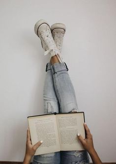 someone is laying down with their feet on an open book