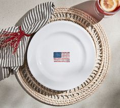 a plate with an american flag painted on it next to a glass of orange juice