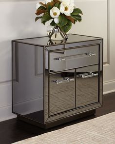 a mirrored side table with flowers on top