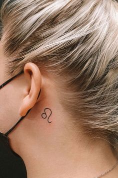 a woman with a small tattoo behind her ear