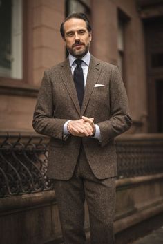 If you’re looking to deepen your fall and winter wardrobe bench, there is no better choice than a dark brown Donegal tweed suit. Its durability makes it a sound men's investment piece that you’ll be able to enjoy for years to come. Its warmth makes it an incredibly practical cold-weather men's suit. The fabric’s unique appearance makes each and every suit a one-of-a-kind garment. It’s exceptionally versatile — you’ve got a full fall suit, tweed jacket, and trousers. Tap to shop this brown suit! Brown Tweed Suit, Fall Suit, Donegal Tweed, Brown Suit, Shirt And Tie, Tweed Suit, Brown Tweed, Brown Suits, Tweed Suits