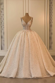 a wedding dress is displayed on a mannequin in front of a white wall