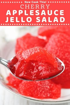 a spoon full of jello sitting on top of a white plate with the words cherry jelly