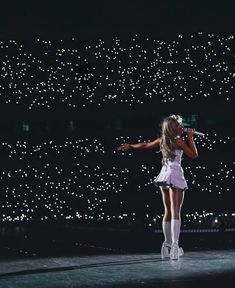 a woman standing on top of a stage holding a microphone