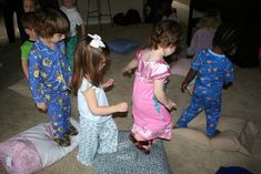 several children in pajamas are playing on the floor