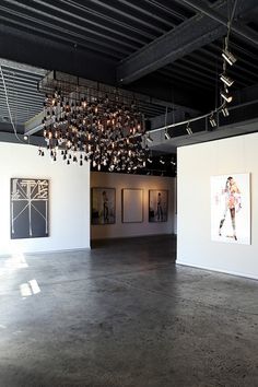 an empty room with paintings and chandelier hanging from the ceiling