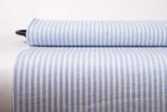 the blue and white striped sheets are folded on top of each other