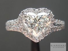 a heart shaped diamond ring with diamonds around it