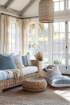 a living room with wicker furniture and large windows