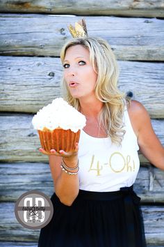 a woman holding a cupcake in front of her face