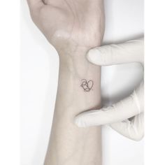 a person's wrist with a small tattoo on the left side of their arm