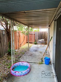 an empty backyard with a pool and cleaning equipment