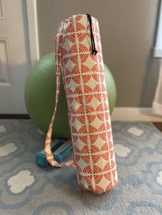 an orange and white bag sitting on top of a blue mat next to a green ball