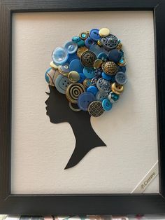 a woman's head is surrounded by buttons in a shadow frame on the wall