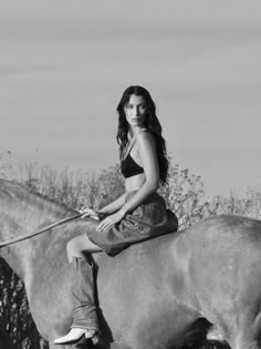 a woman sitting on top of a horse