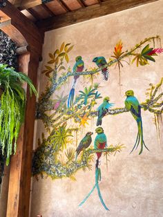 a mural on the side of a building with colorful birds and plants painted on it