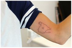 a person's arm with a small map tattoo on the left side of their arm