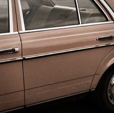 a brown car parked in front of a building