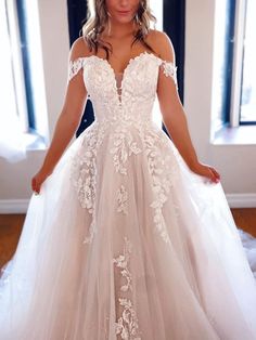 a woman in a wedding dress posing for the camera with her hands on her hips