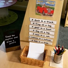 a wooden sign sitting on top of a table next to a basket filled with pencils