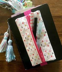 an open notebook on a wooden table with tassels