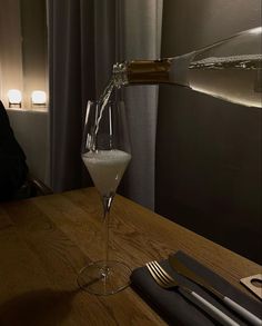 a glass filled with liquid sitting on top of a wooden table