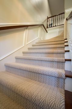 a set of stairs with carpet on the bottom and handrails to the second floor