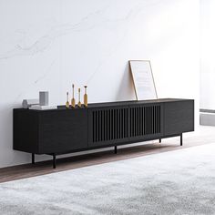 an entertainment center in a living room next to a white wall and wooden flooring