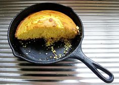 a cake in a skillet on top of a metal table with it's slice missing