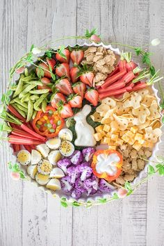 a platter filled with different types of food on top of a white wooden table