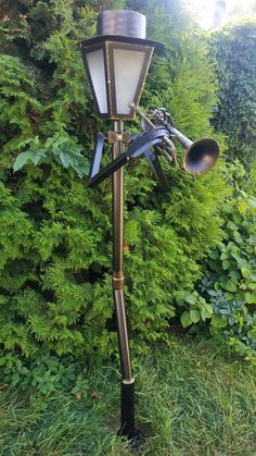 an old fashioned street light in front of some bushes